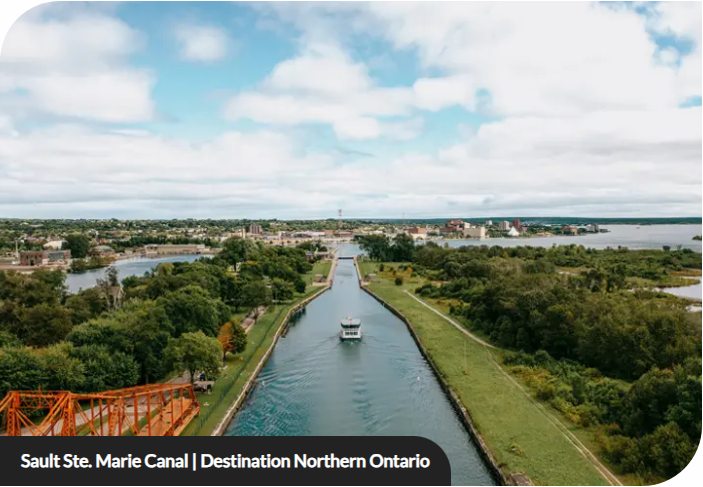 Aerial view of the Sault Ste. Marie Canal with a boat travelling toward the city